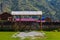 Gate with a fence and a canopy from the rain on a country villa in the mountains with a green lawn in the yard