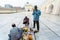 At the gate of the mosque, two buyers are examining the smell of a perfume vendor