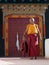 Gatekeeper monk in from of ancient colorful gate of Hemis monastery, India