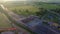 Gates of toll collection area with few cars entering highway, green field around