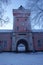 Gateway to Suomenlinna fortress island via historical jetty barracks and clock tower on cold winter morning.