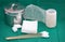 Gauze,stainless jar,net roll bandage ,swab,cotton wool on green