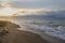 Gava Playa beach in Castelldefels, Barcelona, Spain. Bright sun, dark clouds, beautiful coastline. Large waves and fog in the back