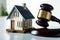 gavel closeup, striking down near a small house model real estate law