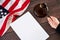 Gavel in judges hand, American flag, blank sanction list on wooden table