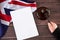 Gavel in judges hand, United Kingdom flag, blank sanction list on wooden table