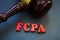 Gavel and letters FCPA Foreign Corrupt Practices Act on a wooden surface.