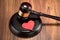 Gavel and red heart on table