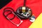 Gavel with stethoscope and pills on German flag. Medical law