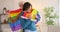 Gay couple dancing with rainbow LGBT flag at home