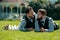 Gay couple laying on grass. Portrait of happy gay couple on wedding day. Concept of same sex love and LGBT rights.