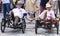 A gay couple riding the recumbent tricycle and holding hands  attending the Gay Pride parade in Munich
