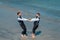 Gay grooms walking together on sea beach during Wedding day. Romantic men in sea water. Gay with partner with care and