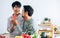 Gay LGBT sweet Asian couple wearing pajamas, smiling with happiness and love, eating, feeding watermalon, healthy fruits for