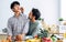 Gay LGBT sweet Asian couple wearing pajamas, smiling, teasing and pinching cheek with happiness and love, eating healthy fruits