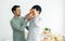 Gay LGBT sweet happy Asian couple wearing pajamas, smiling, taking care, teasing with piece orange on eyes, eating, healthy fruit