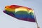 Gay pride flag on blue sky background