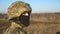 Gaze of male ukrainian army soldier in helmet and balaclava outdoor. Profile view of young military man looking with