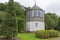 A gazebo building set amongst shaped trees and shrubs