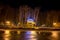 Gazebo with electric garlands near pond in city park at winter