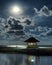 Gazebo and moon in water\'s reflection. Night landscape