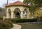 Gazebo, sidewalk, flower bed, bushes and trees in Flippen Park in Highland Park in Dallas, Texas