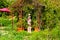 Gazebo with a status in the garden with lush green vegetation