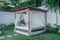 Gazebo with a wooden bed under a mosquito grid on a outside