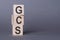 GCS Glasgow Coma Scale - text, written on wooden blocks, on gray background