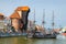 Gdansk, Poland, April 15, 2018: Medieval wooden ship on Motlawa river water, typical colorful houses buildings and Zuraw Crane