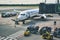 Gdansk / Poland - August 4 2019: Checked freight cargo luggage being driven towards a Ryanair aeroplane on the runway at Gdansk