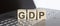GDP abbreviation stands for written on a wooden cube on laptop