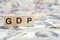 GDP or Gross domestic product wooden block on US Dollar bank note