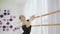 Geautiful ballerina dressed in black tutu dancing near a big window.