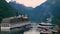 GEIRANGER, NORWAY - 16 JUN 2019: Time lapse clip of ferry boat full of cars and buses leaving dock, turning and sailing off