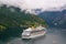 Geiranger, Norway - January 25, 2010: adventure, discovery, journey. Cruise ship in norwegian fjord. Passenger liner docked in por