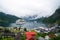 Geiranger, Norway - January 25, 2010: ship in norwegian fjord on cloudy sky. Ocean liner in village harbor. Travel destination, to