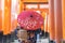 Geishas girl wearing Japanese kimono among red wooden Tori Gate at Fushimi Inari Shrine in Kyoto, Kimono is a Japanese traditional