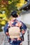 Geishas girl wearing Japanese kimono among red wooden Tori Gate at Fushimi Inari Shrine in Kyoto, Kimono is a Japanese traditional