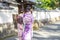 Geishas girl wearing Japanese kimono among red wooden Tori Gate at Fushimi Inari Shrine in Kyoto, Kimono is a Japanese traditional