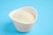 Gelatin powder in bowl on light blue background, closeup