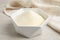 Gelatin powder in bowl on white wooden table, closeup