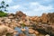 Gender fluid black person poses gracefully stands on rocks in creek in natural still water pool. Queer ethnic fashion