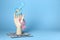 Gender pay gap. Wooden mannequin hand with symbols and dollar banknotes on light blue background, space for text