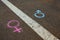 Gender symbols or signs for male and female drawn with chalk on asphalt. The concept of gender equality