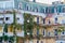 General architecture - facade of traditional residential building, covered with ivy and grape varnish.