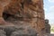 General view, Badami Caves, Karnataka. Unfinished cave on the left, and tourists entering in the cave 2 below.