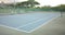 General view of empty outdoor tennis court surrounded by trees, slow motion