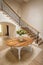 General view of house interior with table and vase with flowers in spacious hallway and staircase