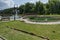 General view of public garden in residential district with artificial pond, fountain and bridge, town Delchevo, Macedonia